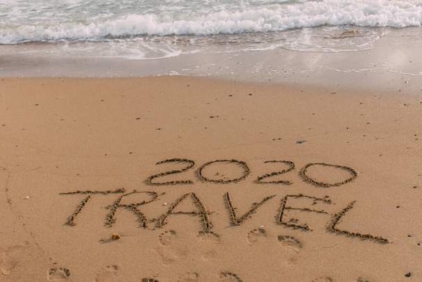 summer beach with 2020 travel lettering on sand near sea  - Photo, Image