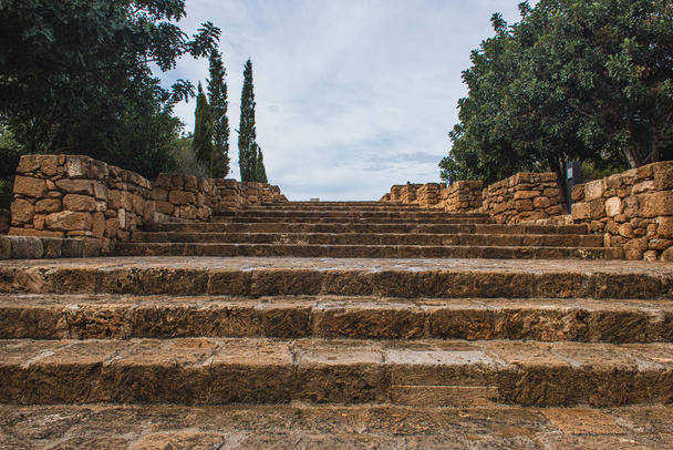 starověké schody v blízkosti zelených stromů proti obloze s mraky  - Fotografie, Obrázek