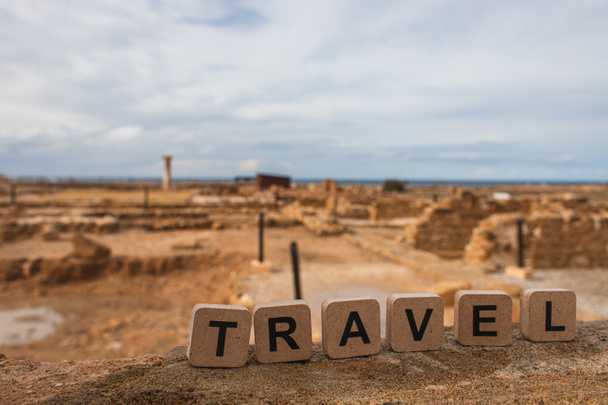 cubos de madeira com letras de viagem perto de ruínas da antiga Casa de Teseu
   - Foto, Imagem