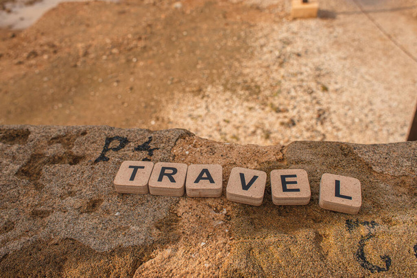 wooden cubes with travel lettering on ancient ruins in cyprus  - Φωτογραφία, εικόνα