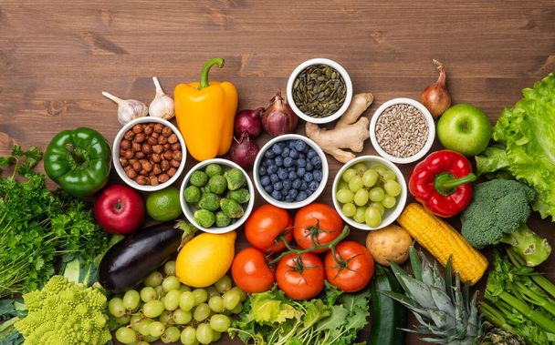 Egészséges étkezési összetevők: friss zöldségek, gyümölcsök és szuperételek. Táplálkozás, diéta, vegán étel koncepció. Fa háttér - Fotó, kép