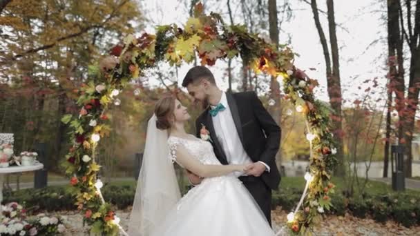 Friss házasok. Kaukázusi vőlegény menyasszonnyal egy hektárnyi virág mellett. Esküvői pár - Felvétel, videó
