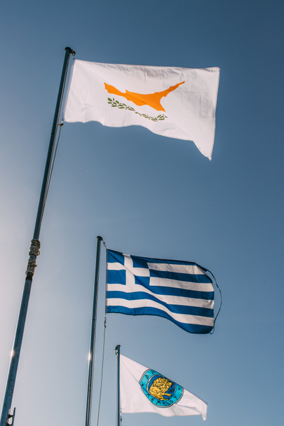 άποψη χαμηλής γωνίας των εθνικών σημαιών της Ελλάδας και του πύου κατά του γαλάζιου ουρανού  - Φωτογραφία, εικόνα