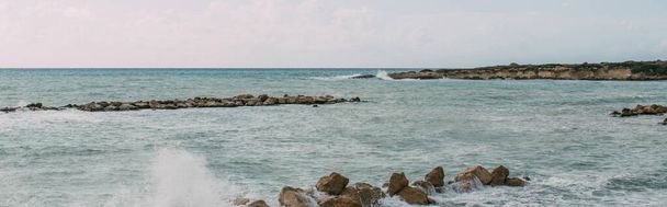 panoraama ampui kiviä lähellä Välimerta taivasta vasten
  - Valokuva, kuva
