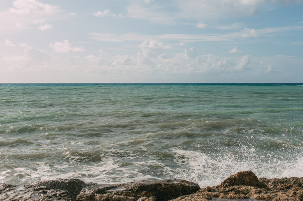 Nasse Felsen am Mittelmeer gegen blauen Himmel mit Wolken  - Foto, Bild