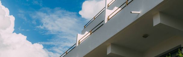 panorámás felvétel a modern épület ellen kék ég fehér felhők  - Fotó, kép
