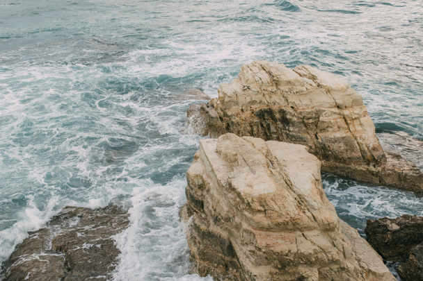 white foam near wet rocks in water of mediterranean sea in cyprus   - Фото, изображение