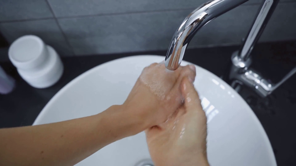 обрізаний вид молодої жінки, що миє руки в раковині
 - Кадри, відео