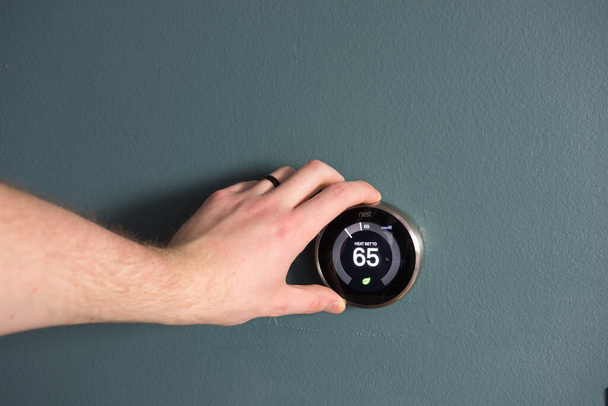Zelená technika - Elektrický termostat pro úsporu peněz a energie. Ruka dárek k provedení úprav. - Fotografie, Obrázek