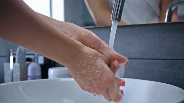 Banyoda ellerini yıkayan genç bir kadın manzarası. - Video, Çekim