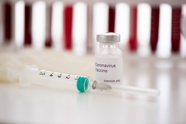 Testbuizen met bloedmonster Covid-19 coronavirus. Vaccin en injectiespuit Het wordt gebruikt voor preventie, immunisatie en behandeling tegen COVID. - Foto, afbeelding