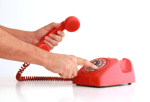 Mãos a fazer uma chamada no telefone vermelho vintage
 - Foto, Imagem