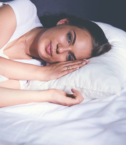 όμορφη νεαρή ξανθιά γυναίκα στον ύπνο στο κρεβάτι - Φωτογραφία, εικόνα