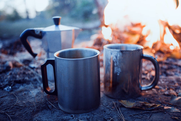 happy trip - bonfire and geyser coffee maker with cup in the foreground - Фото, изображение