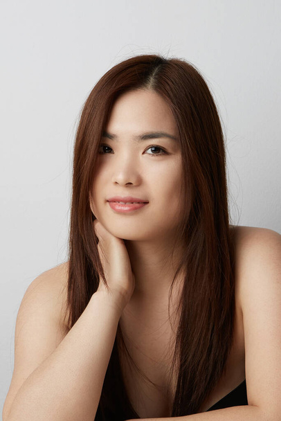 Függőleges portré ázsiai fiatal nőről, aki a kamerába néz. Szépségkoncepció.  - Fotó, kép