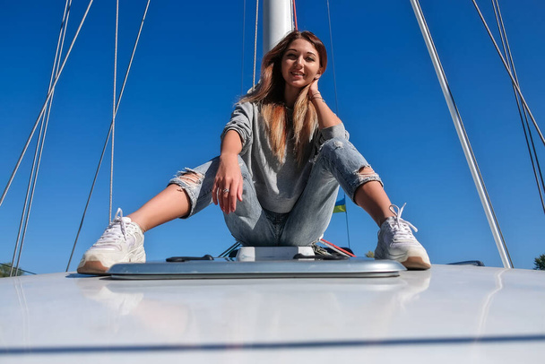 Красивая молодая женщина позирует на яхте. Модель садится на борт
 - Фото, изображение