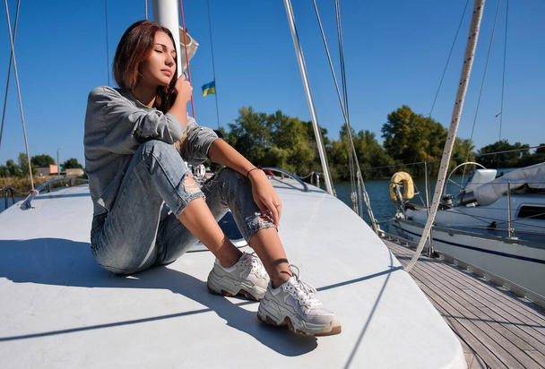 Gyönyörű fiatal nő pózol a jachton. A modell a fedélzeten vitorlázik. - Fotó, kép