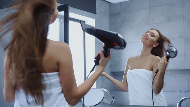 Banyoda saçlarını kurutan banyo havlusuyla güzel genç bir kadın. - Video, Çekim
