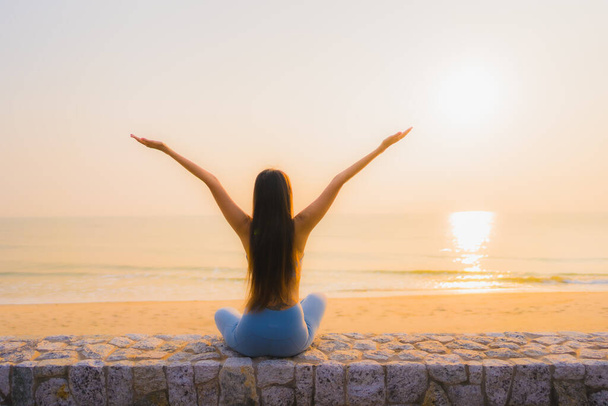 Portrét mladá asijská žena dělat meditaci kolem moře pláž oceán při východu slunce pro zdraví - Fotografie, Obrázek