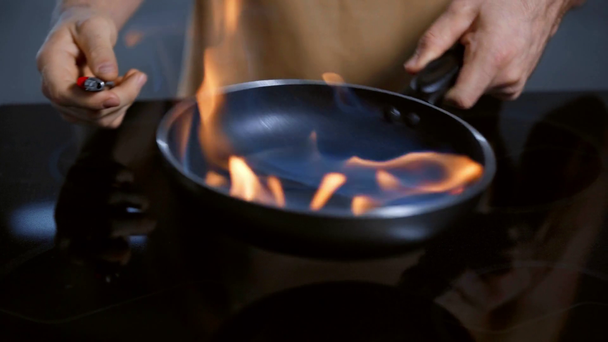 καλλιεργημένη άποψη του ανθρώπου που βάζει φωτιά στο αλκοόλ στο τηγάνι - Πλάνα, βίντεο