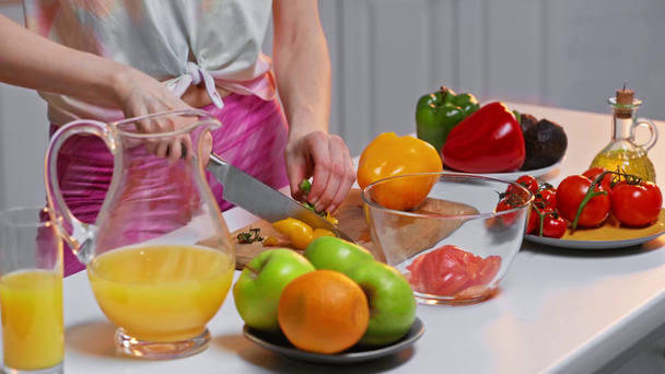 Vista recortada de la mujer cocinando ensalada fresca cerca del jugo de naranja en la mesa
 - Metraje, vídeo