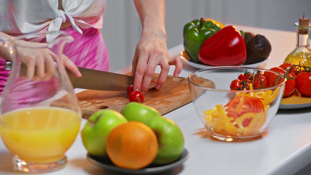 キッチンでテーブルの上で健康的なサラダを調理女性の作物ビュー - 映像、動画