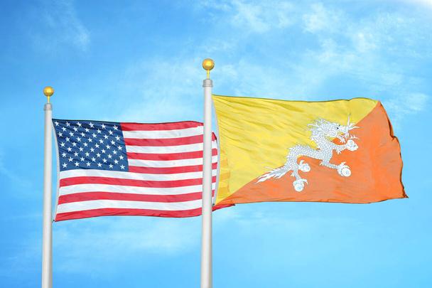 United States and Bhutan  two flags on flagpoles and blue cloudy sky background - Photo, Image