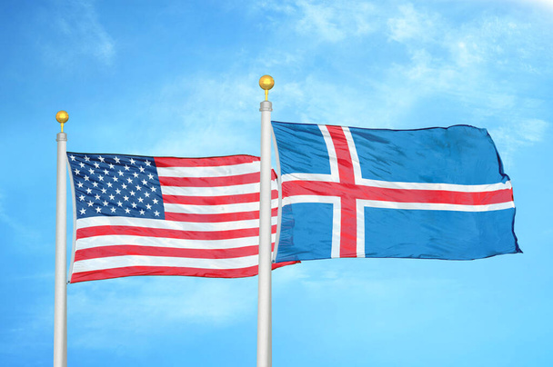 Verenigde Staten en IJsland twee vlaggen op vlaggenmasten en blauwe bewolkte lucht achtergrond - Foto, afbeelding