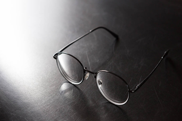 Focus selettivo di occhiali su sfondo nero e spazio copia con luce e ombra
 - Foto, immagini
