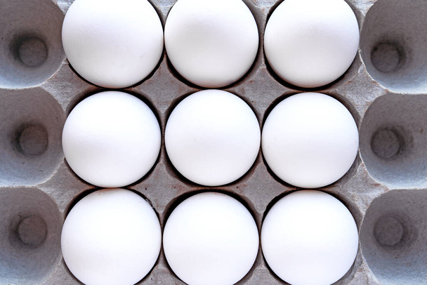White eggs in a package on a blue background close-up view from above.  - Φωτογραφία, εικόνα
