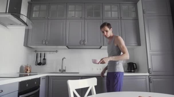 Young man having breakfast at the kitchen. - Кадри, відео