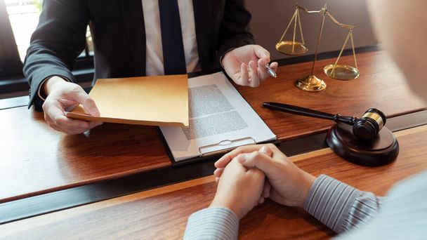 Юрист-нотариус или судья мужского пола консультирует или обсуждает договорные документы с клиентом-предпринимателем в офисе, юридические и юридические услуги
 - Фото, изображение