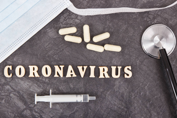 Inscripción coronavirus con máscara quirúrgica o protectora, tabletas, jeringa y estetoscopio. Nuevo brote de coronavirus. 2019-nCoV
 - Foto, Imagen