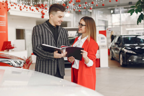 Stylish and elegant couple in a car salon - Foto, afbeelding