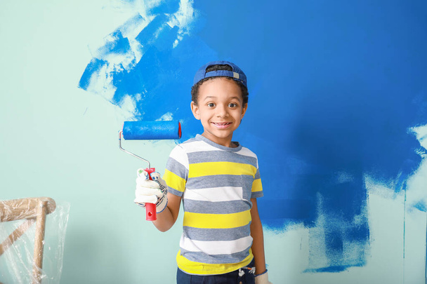 Μικρό Αφροαμερικανό αγόρι ζωγραφίζει τοίχο στο δωμάτιο - Φωτογραφία, εικόνα