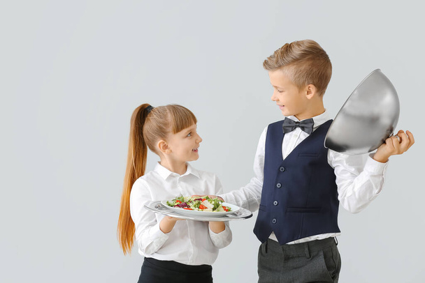 Cute little waiters on light background - Photo, Image
