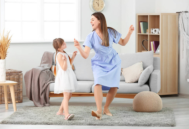 Feliz madre y su pequeña hija bailando en casa
 - Foto, imagen