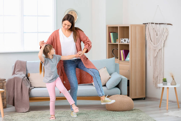 Happy mother and her little daughter dancing at home - Foto, imagen