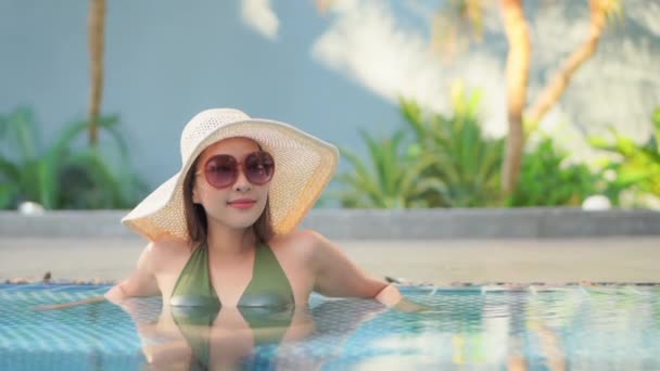 Footage of beautiful young asian woman relax around swimming pool in hotel resort for leisure in vacation - Séquence, vidéo
