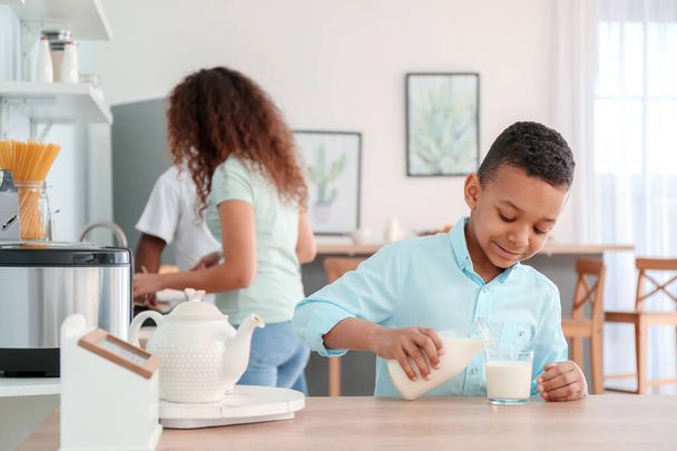 African-American boy drinking milk in kitchen - 写真・画像
