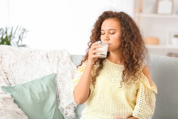 Mujer afroamericana bebiendo leche en casa
 - Foto, Imagen