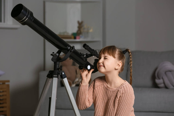 Nettes kleines Mädchen mit Teleskop, das abends Sterne betrachtet - Foto, Bild