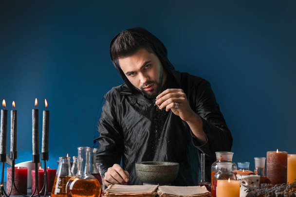 Männlicher Alchemist macht Trank auf dunklem Hintergrund - Foto, Bild