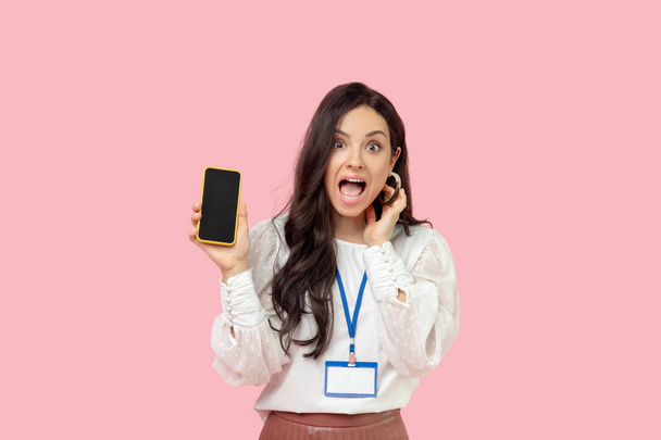 Young woman in a white blouse holding a smartphone - Foto, Imagen