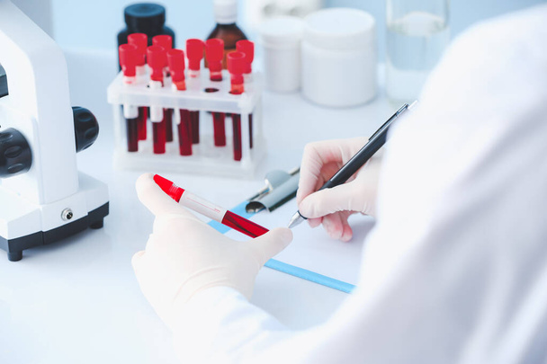 Médico que trabalha com amostras de sangue em laboratório
 - Foto, Imagem