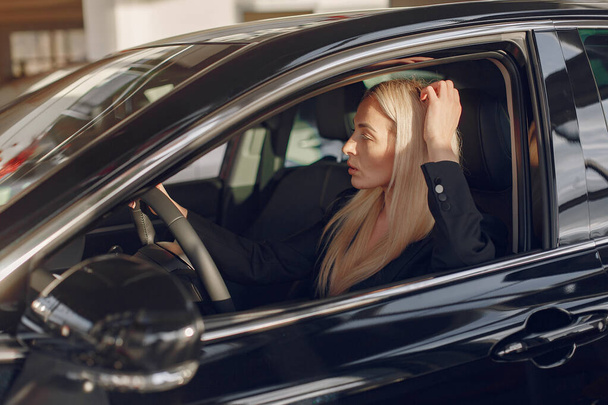 Stylish and elegant woman in a car salon - Valokuva, kuva