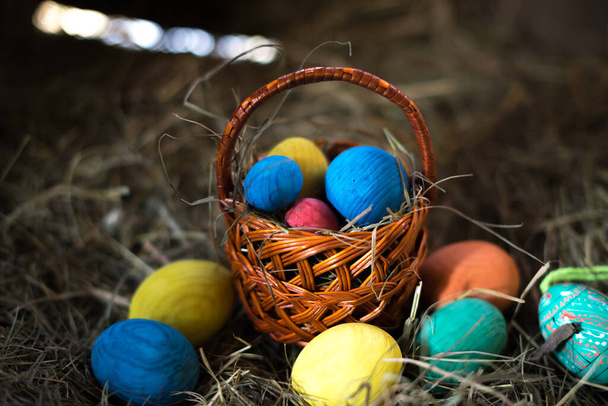 Easter eggs in a basket on a hay with a blurred background - Zdjęcie, obraz