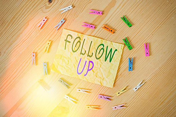 Writing note showing Follow Up. Business photo showcasing a continuation of something that has already been started Colored clothespin papers empty reminder wooden floor background office. - Photo, Image