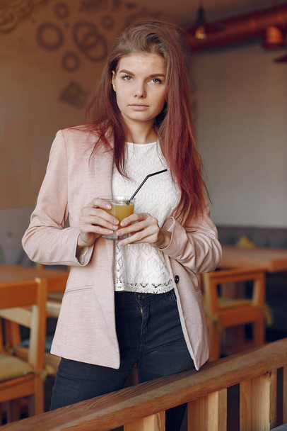 Elegant woman in a pink jacket spend time in a cafe - 写真・画像