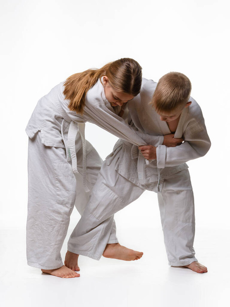 The boy is trying to make a cut for a girl in judo class - Photo, Image